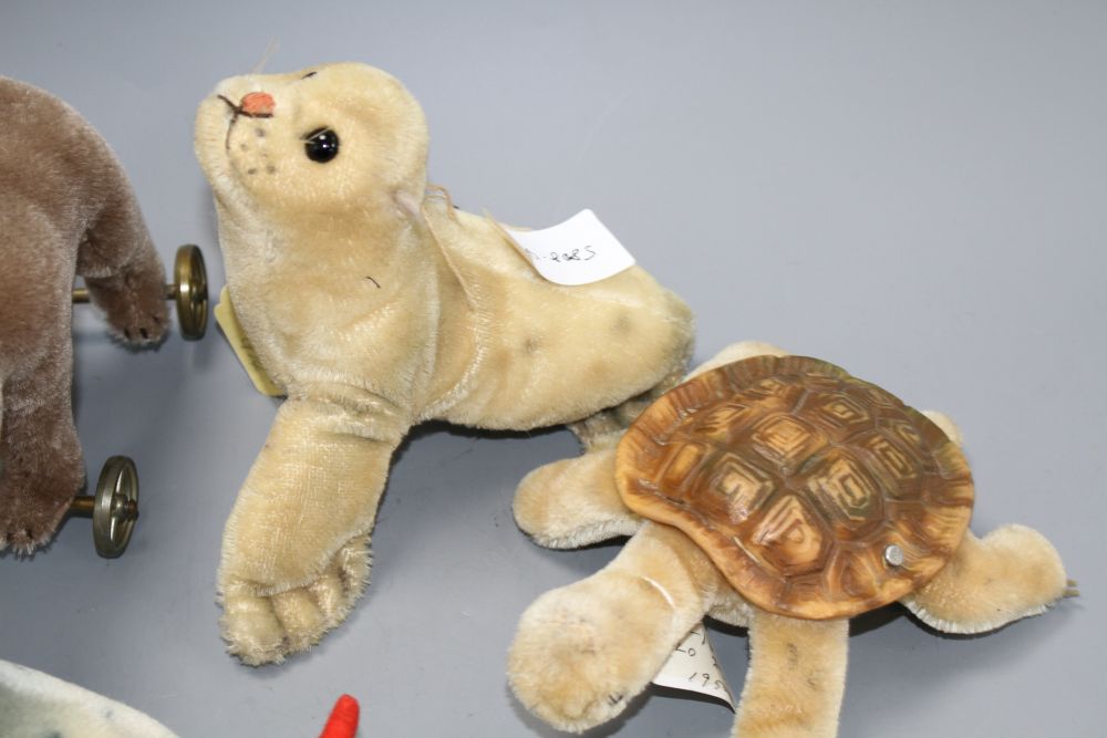 A 1960s Steiff Robby sea lion, another similar larger sea lion, a penguin, a turtle and a more recent bear on wheels